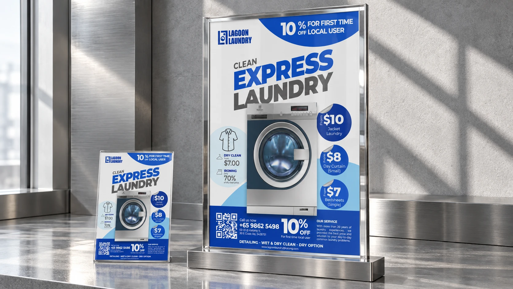 A Lagoon Laundry promotional poster and matching flyer in clear glass stands on a sunlit metallic counter.