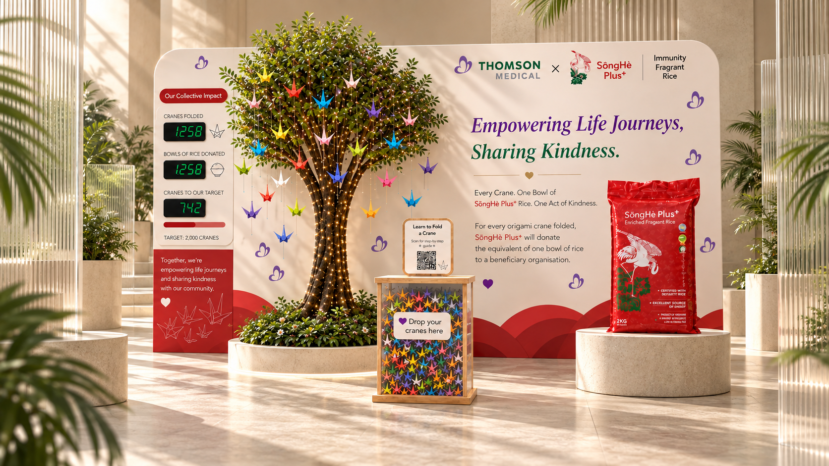 SongHe Plus and Thomson Medical concept display with an origami-crane tree, product presentation and warm sunlit glass surroundings.